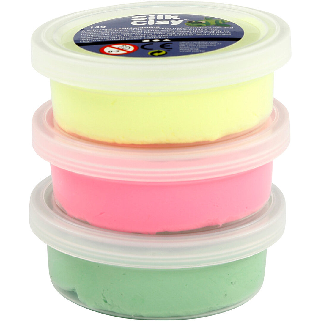 Drie gestapelde potjes Creativ Company Silk Clay boetseerklei in neon geel, roze en groen.