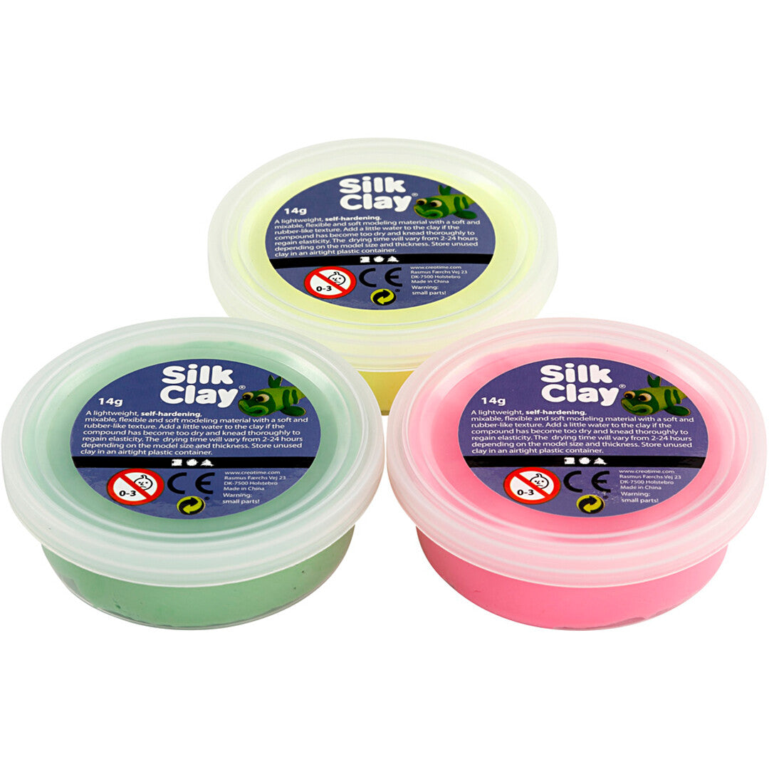 Drie potjes Creativ Company Silk Clay boetseerklei in neon geel, roze en groen, van bovenaf gezien.