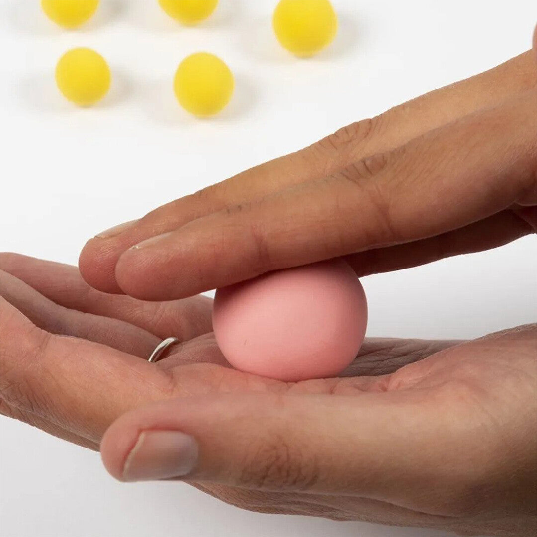 Handen rollen een roze bal van Creativ Company Silk Clay zelfhardende klei.