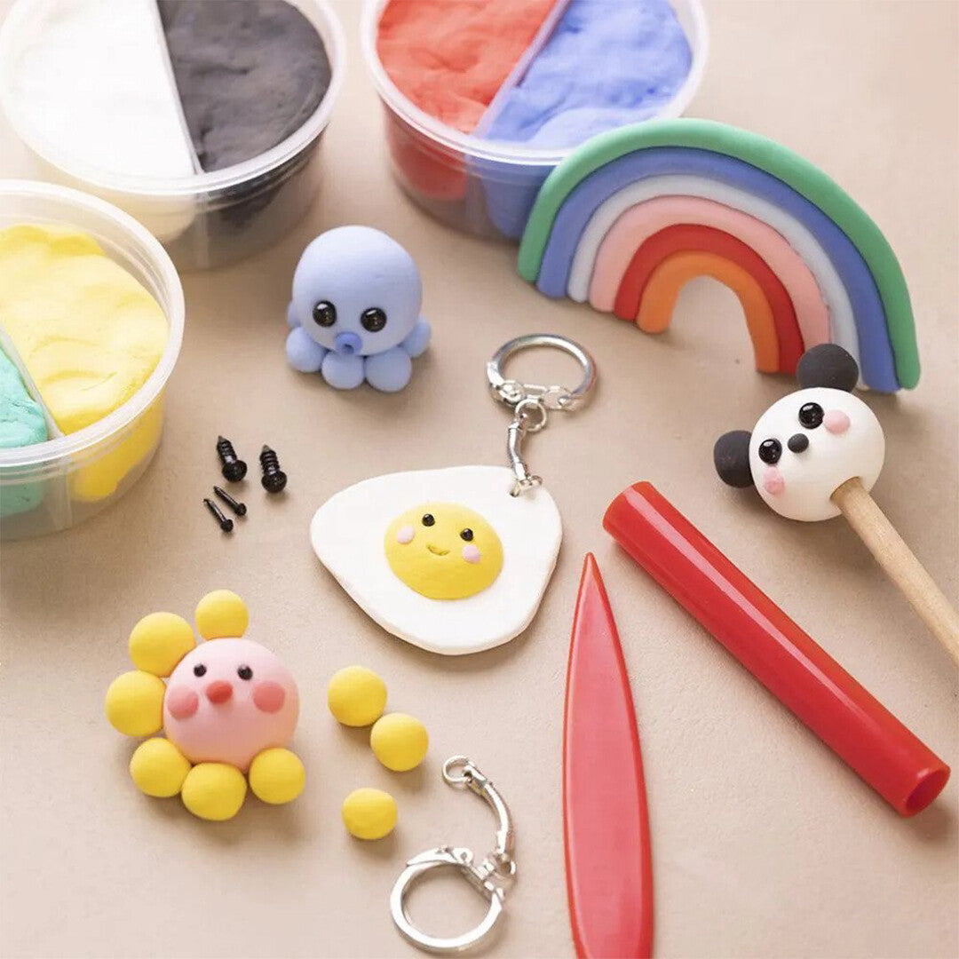 Een overzicht van diverse creaties gemaakt met creativ company Silk Clay, zoals een regenboog, octopus en bloem, met potjes klei en gereedschap.
