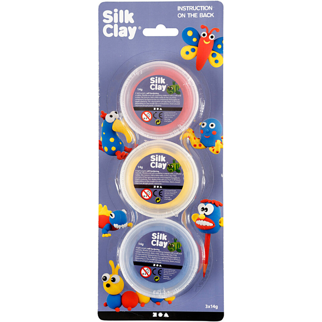 De voorkant van de verpakking van creativ company Silk Clay boetseerklei met drie potjes in primaire kleuren en voorbeelden van creaties.