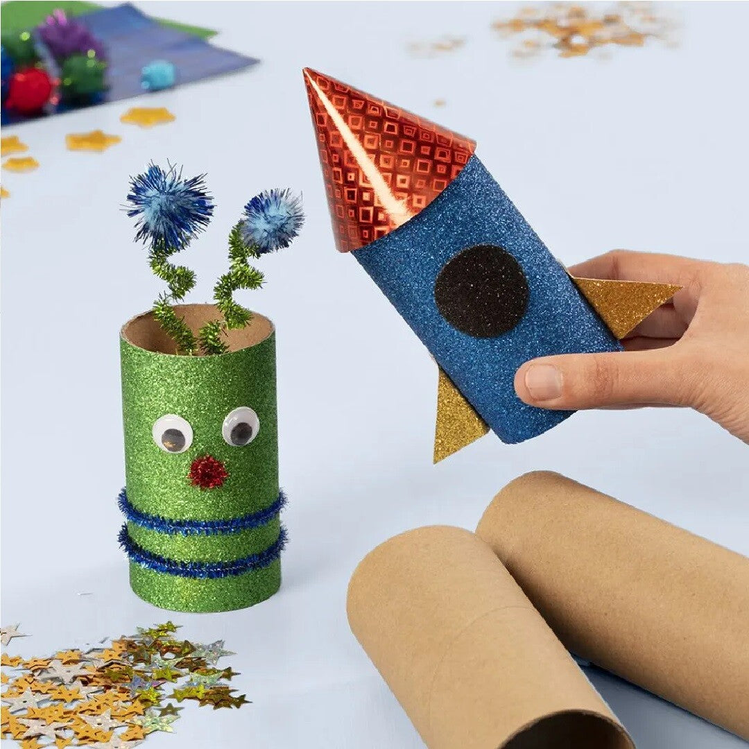 Geknutselde raket en een groen ruimtewezen van kartonnen kokers, gemaakt met de knutselset.