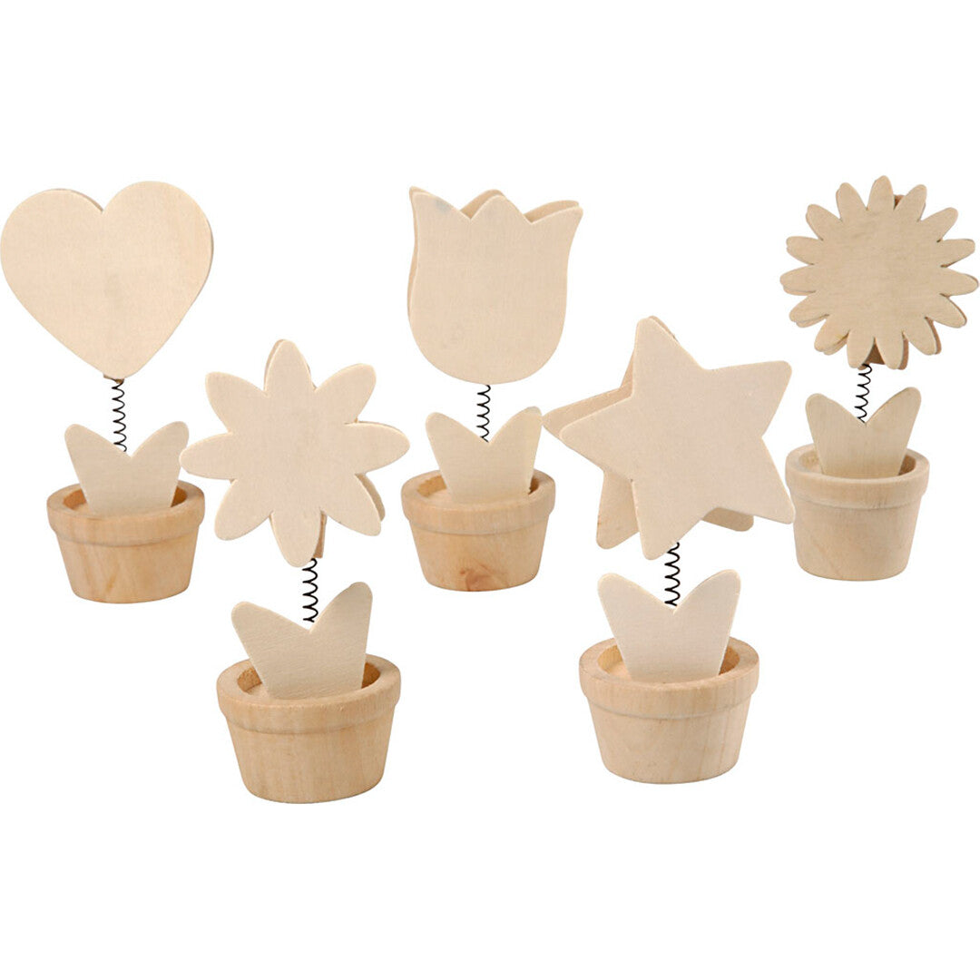 creativ company houten memoclips in de vorm van harten, sterren en bloemen in potjes, schuin van bovenaf gefotografeerd.