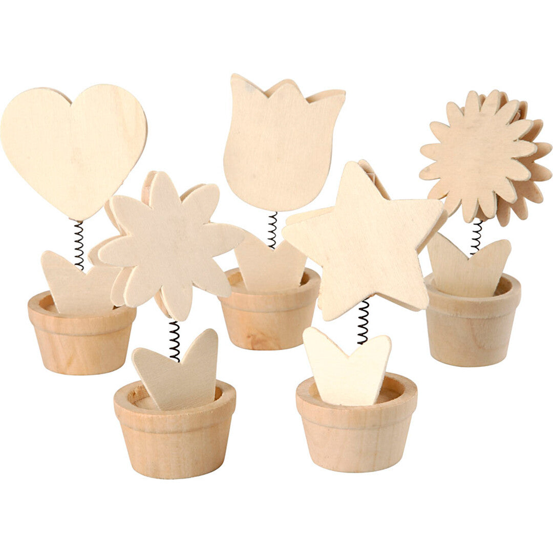creativ company houten memoclips in de vorm van harten, sterren en bloemen in potjes, schuin van bovenaf gefotografeerd.