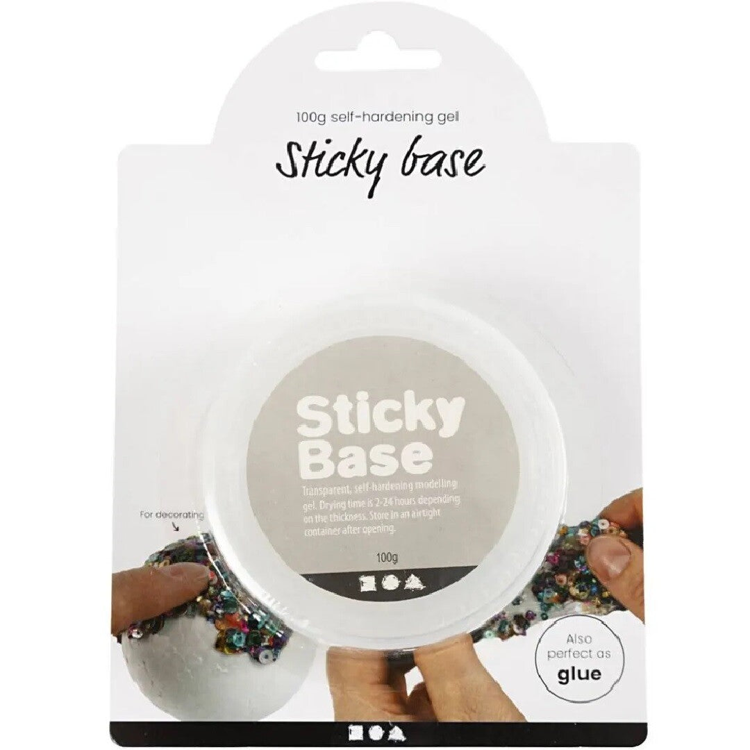 De voorkant van de verpakking van Creativ Company transparante boetseergel, met een witte pot 'Sticky Base' en een voorbeeld van decoreren met pailletten.