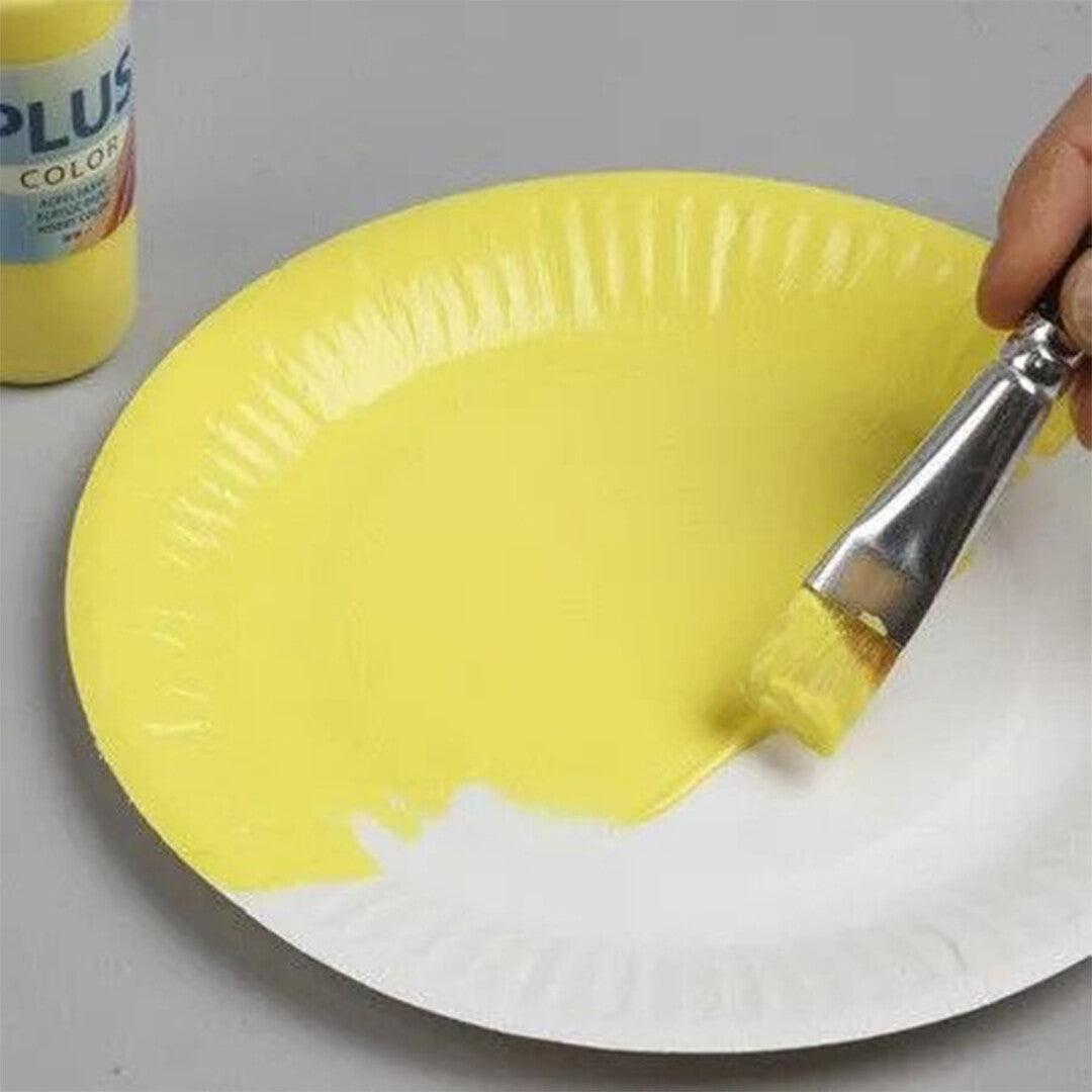 Een hand schildert een geel papieren bord met een kwast en gele verf.