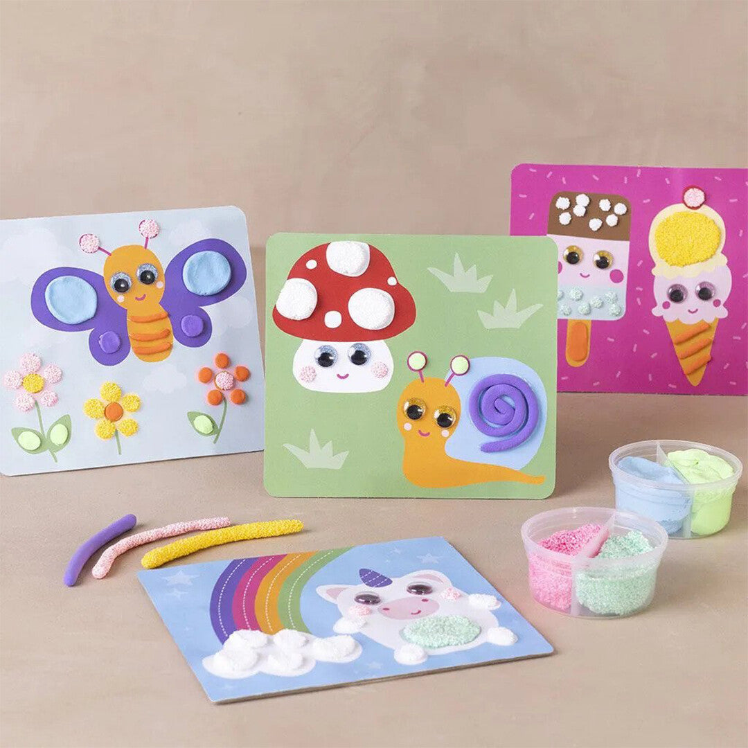 Een collectie knutselkaarten met daarop een vlinder, paddenstoel, slak, ijsjes en een eenhoorn, gemaakt met Creativ Company wiebelogen en klei.
