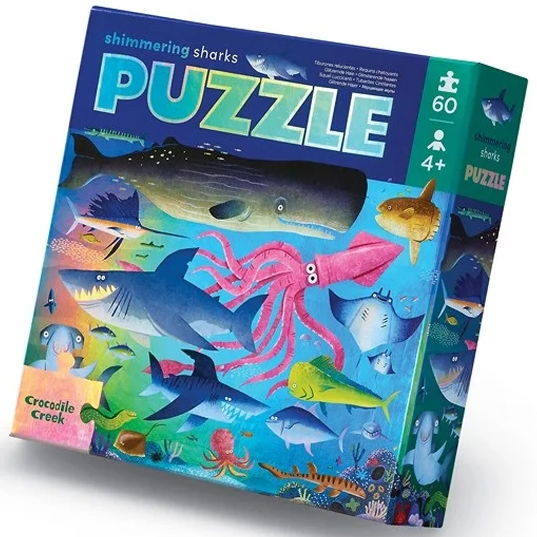 Verpakking van de Crocodile Creek Shimmering Sharks puzzel met 60 stukjes, waarop diverse zeedieren staan afgebeeld.