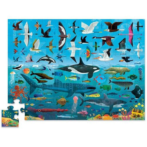 De complete 48-delige vloerpuzzel 'Above + Below' met vogels in de lucht en zeedieren onder water, met één los puzzelstukje.