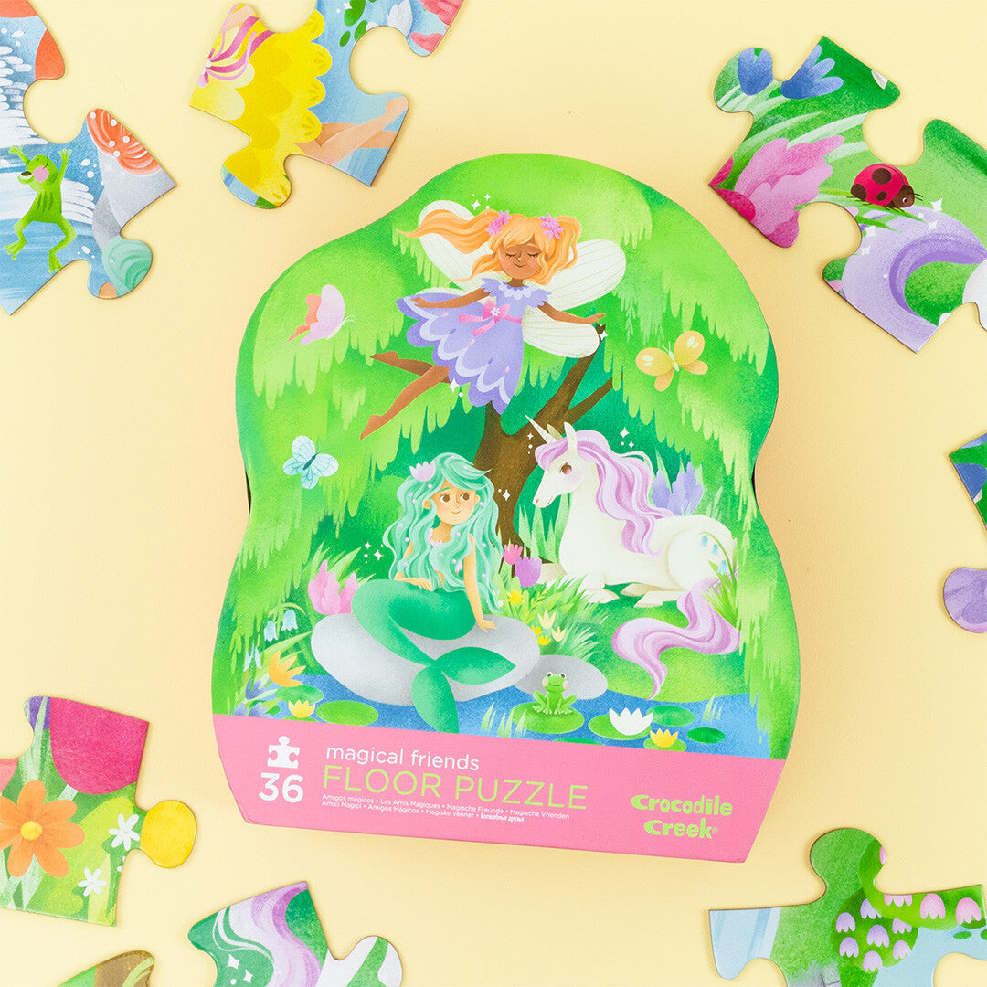 De Crocodile Creek vloerpuzzel verpakking met magische vriendjes, omringd door losse puzzelstukjes.