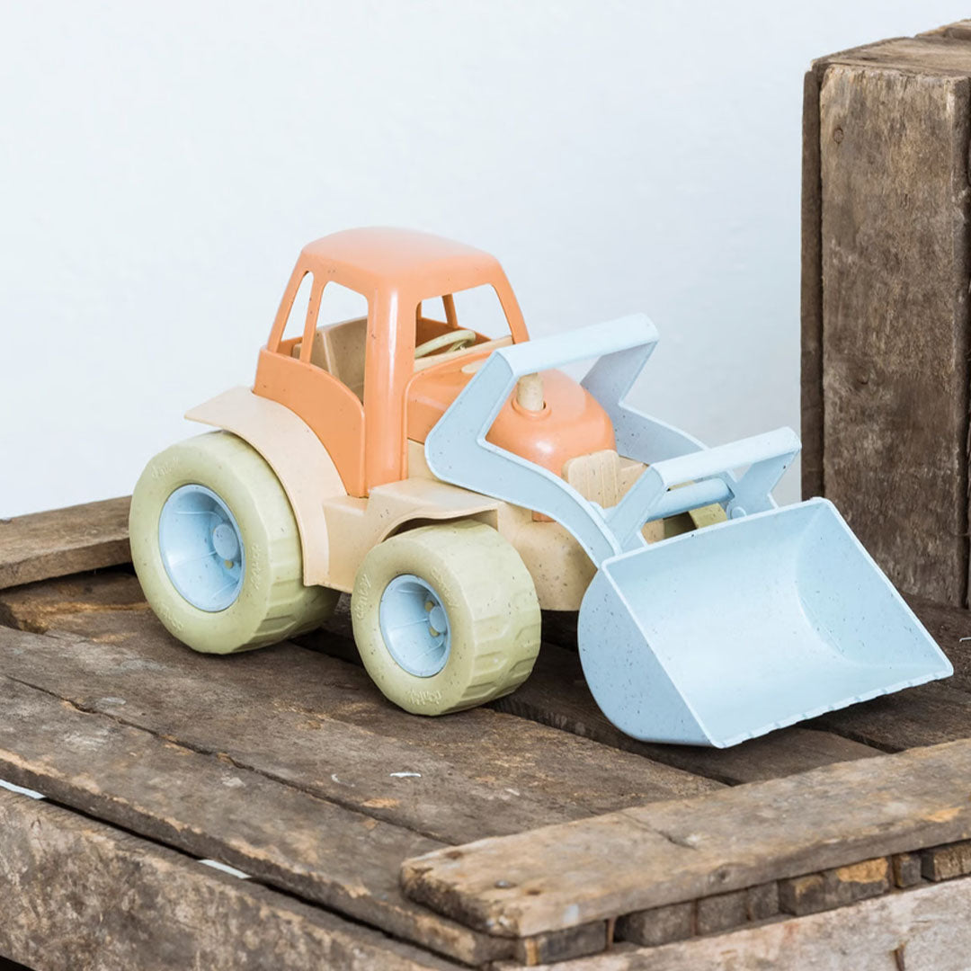 dantoy speelgoedtractor met oranjebruine cabine en lichtblauwe schep op houten kisten.