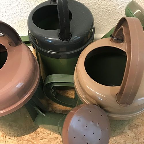 Dantoy Green Bean speelgoed gieters in verschillende kleuren, waaronder grijs en bruin.