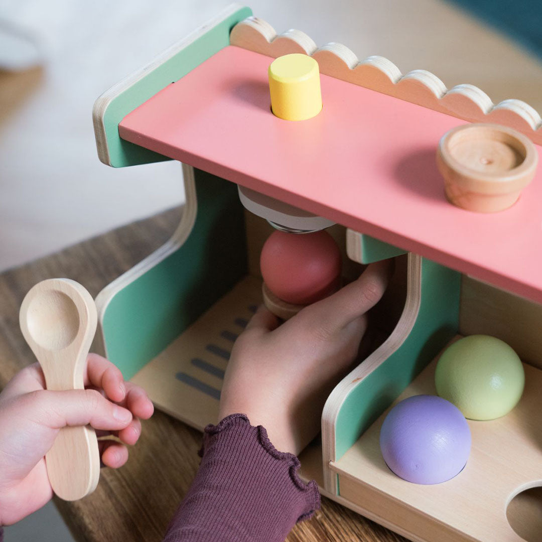 Kinderhanden spelen met de houten ijskraam en pakken een ijsbol.