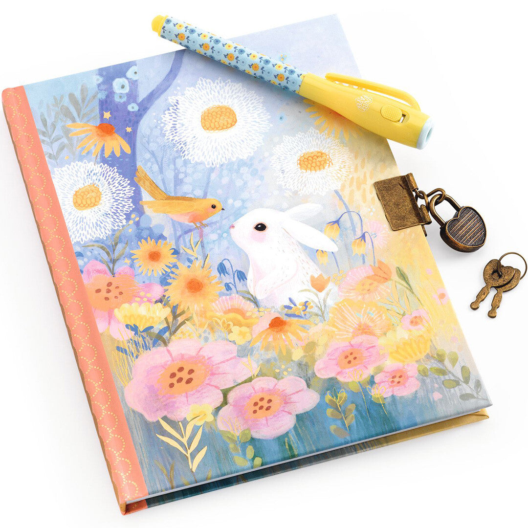 Djeco dagboek met konijn en bloemen, de magische pen erop en het slotje met sleutels ernaast.