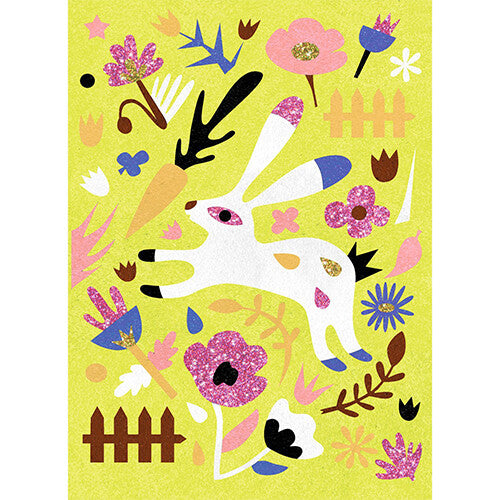 Een voltooid zandkunstwerk met een wit konijn, bloemen en een hek op een geelgroene achtergrond.