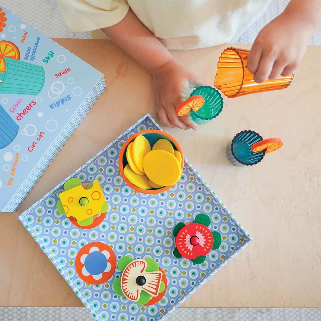 Kind speelt met de Djeco aperitief speelset, schenkt uit de kan in een glas.