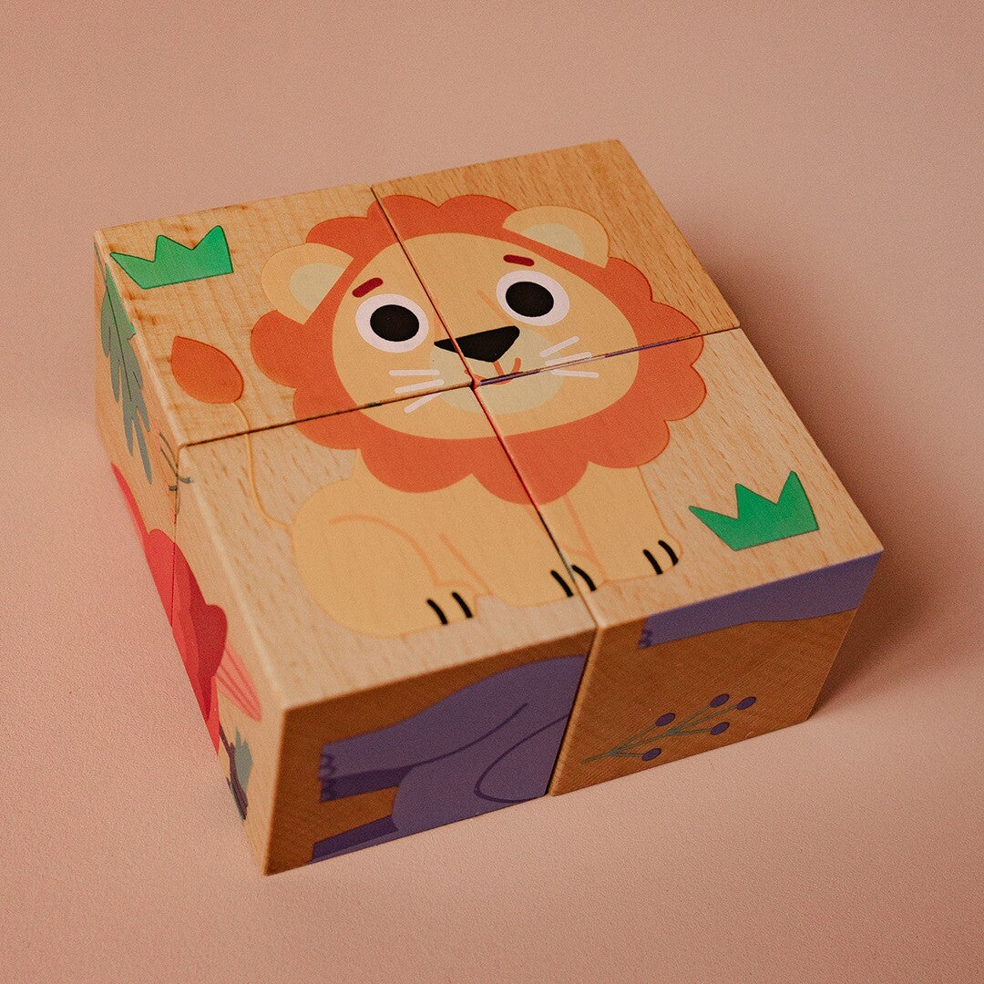 Een complete Djeco houten blokpuzzel van een leeuw, liggend op een roze ondergrond.