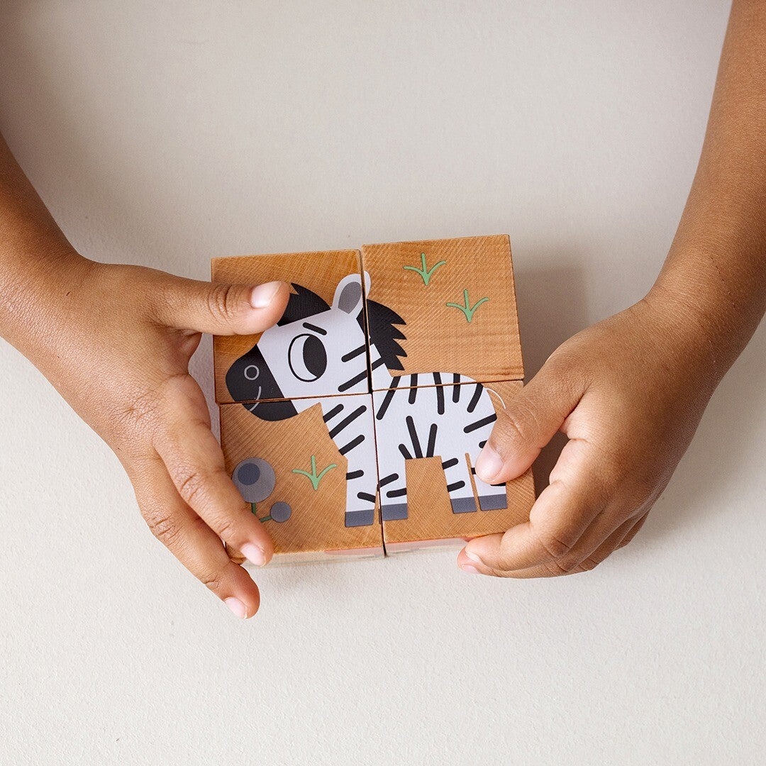 Kinderhanden houden een complete Djeco houten blokpuzzel van een zebra vast.