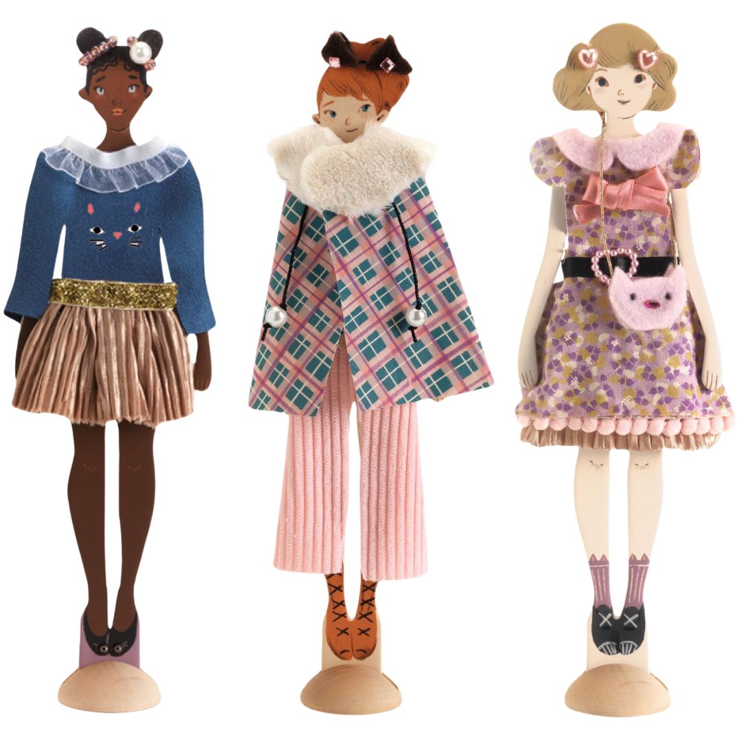 Drie Djeco aankleedpoppen met verschillende modieuze outfits en kattenaccessoires.