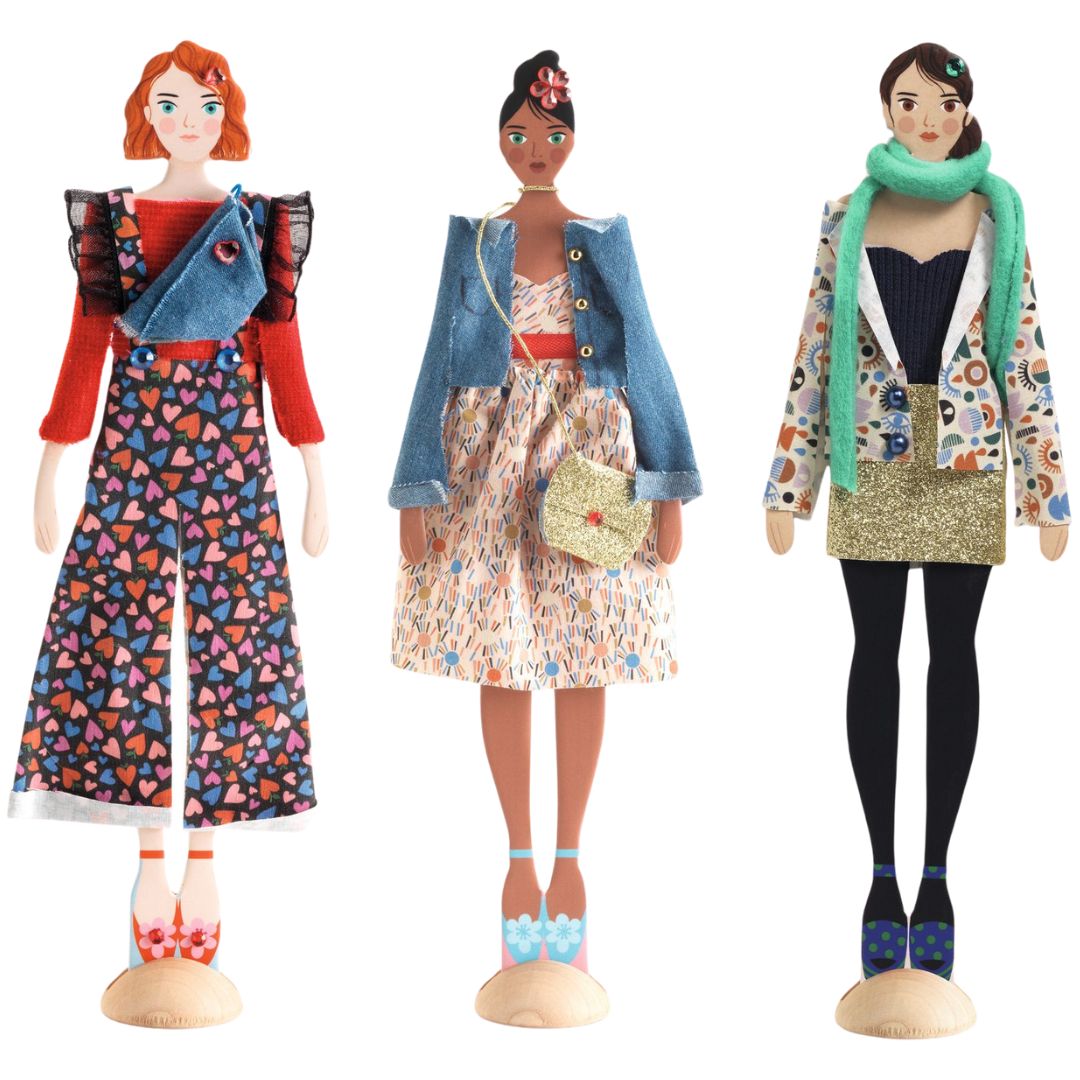 Drie Djeco aankleedpoppen met verschillende, zelfgemaakte mode-outfits.