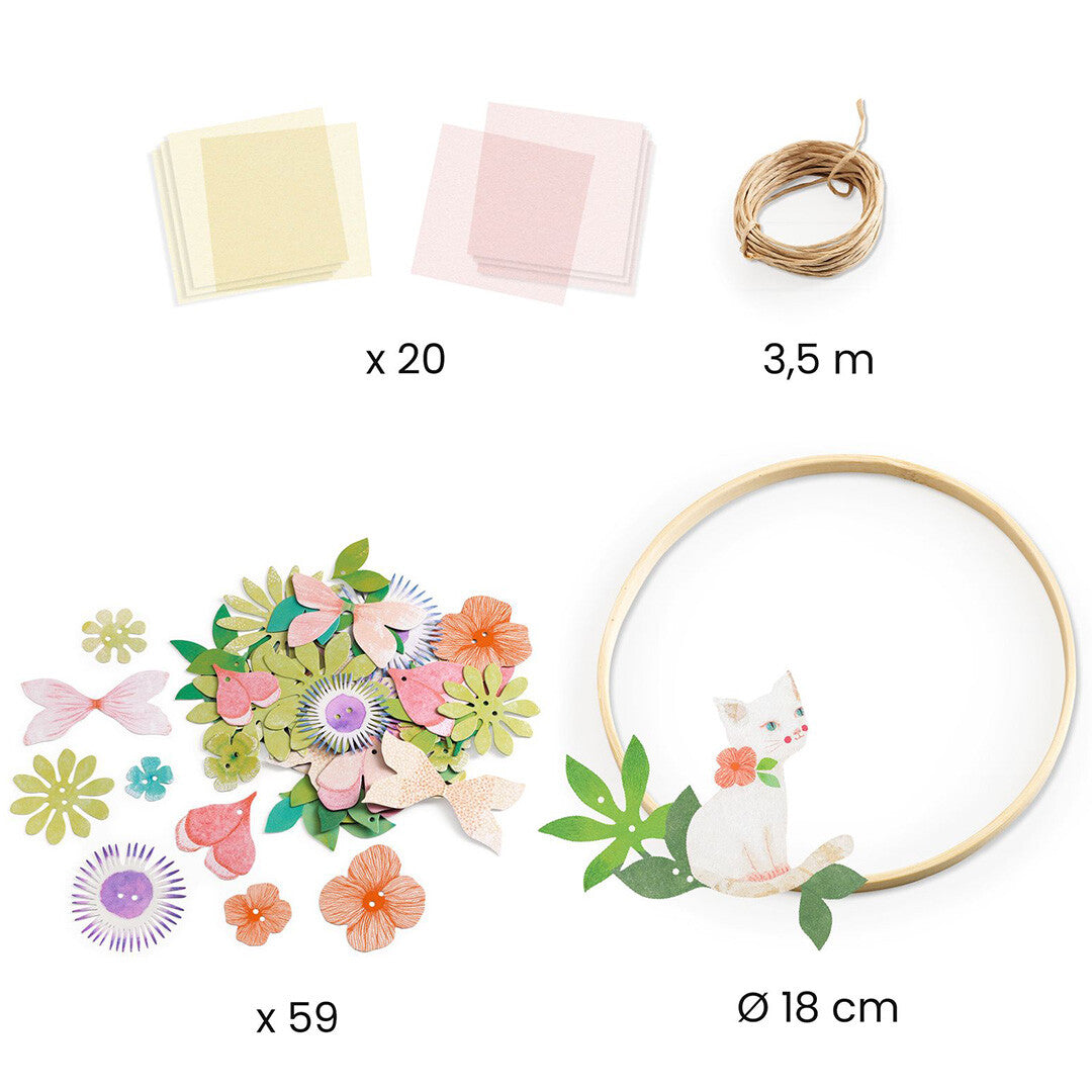 Overzicht van alle onderdelen van de knutselset, inclusief papieren bloemen, kartonnen kat, touw en houten ring.
