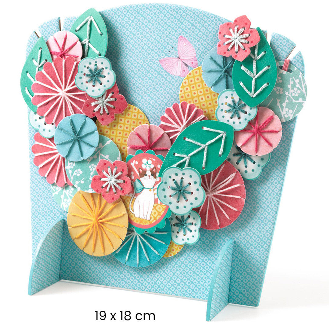 De gemaakte bloemenketting van de knutselset Flora op een standaard, met de afmetingen 19 x 18 cm.