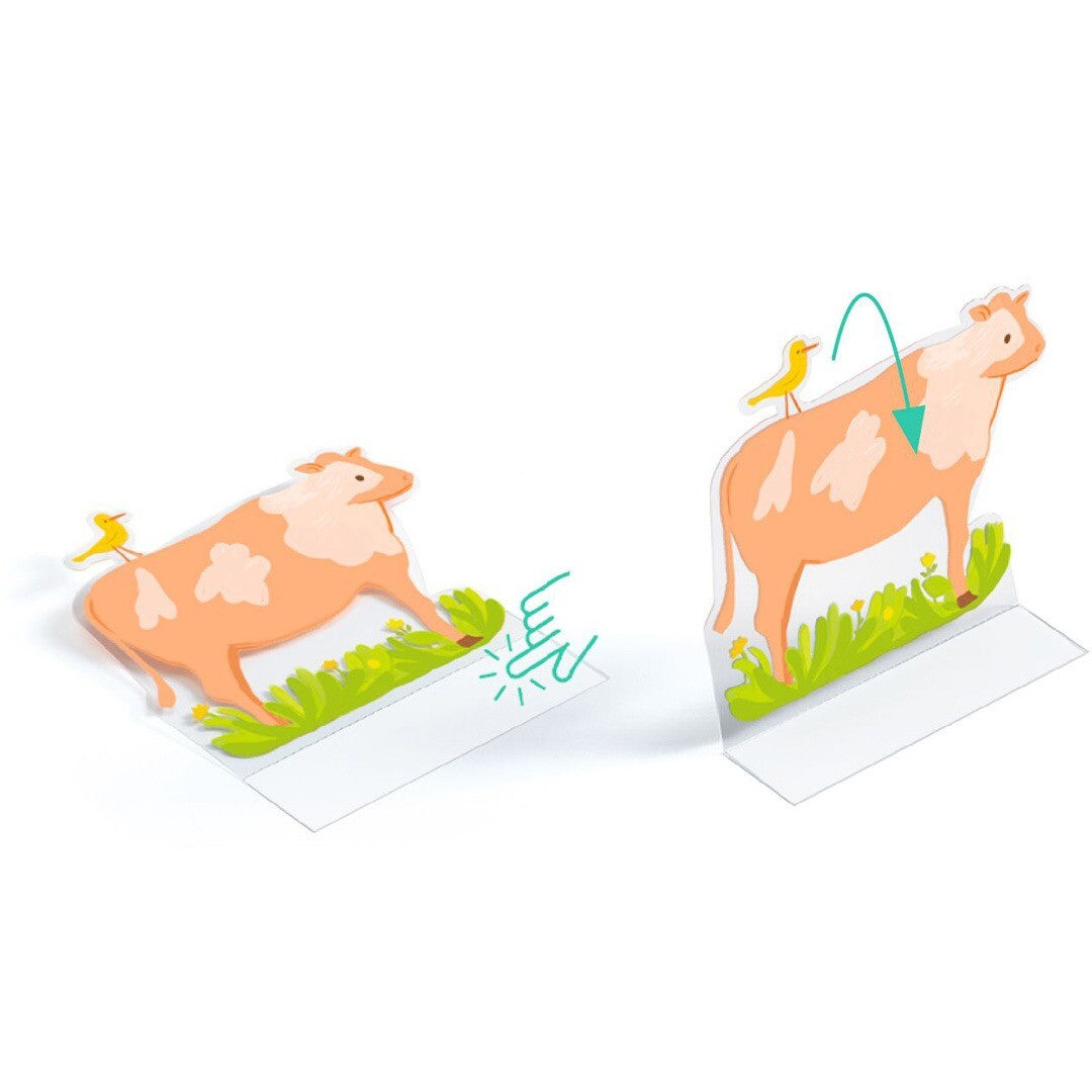 Detail van de Djeco knutselset met herbruikbare 3D stickers toont twee koeien, waarvan één plat en één opstaand, met een pijl die de vouwfunctie aangeeft.
