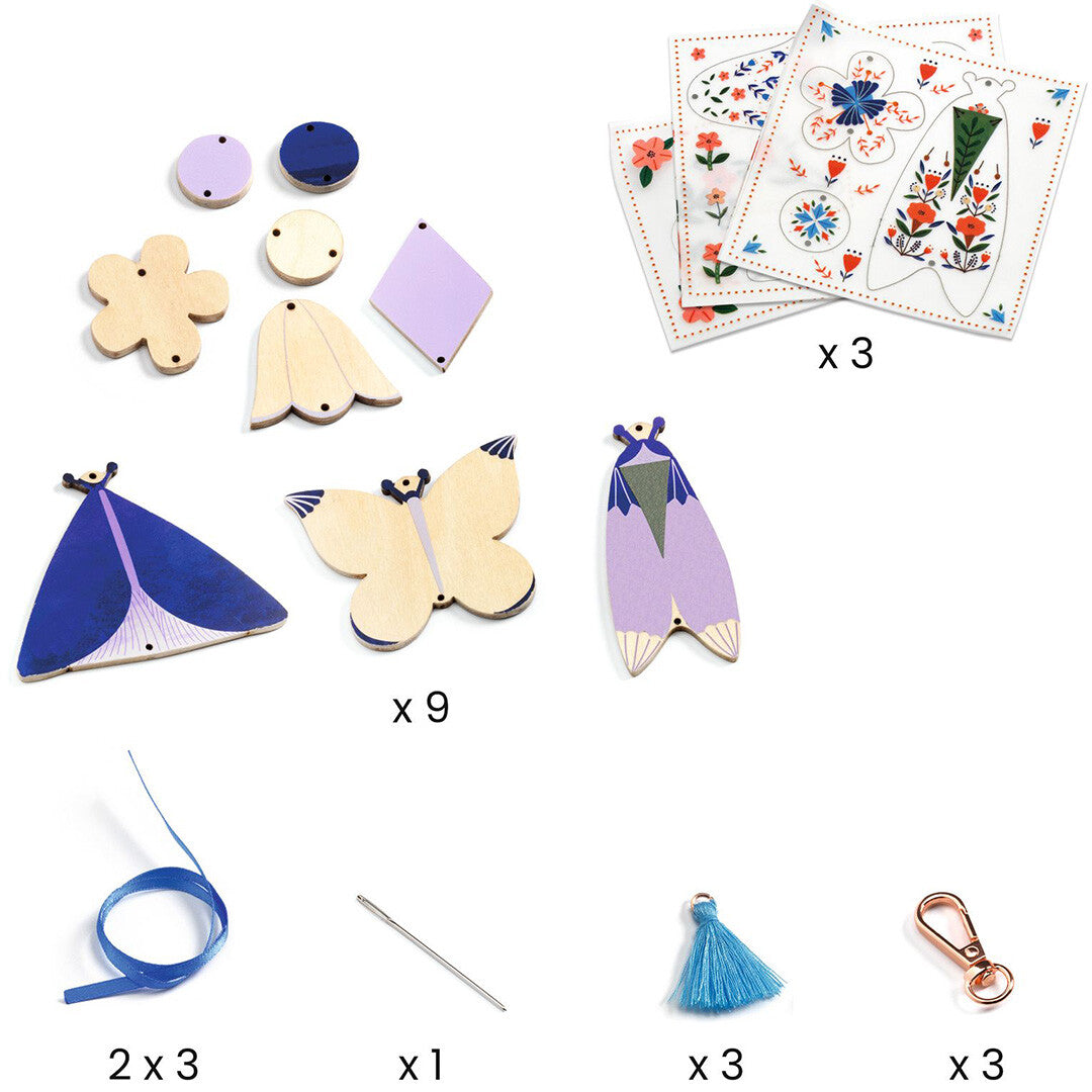 Alle onderdelen van de Djeco knutselset voor sleutelhangers, inclusief houten vormen, stickers, linten en kwastjes.