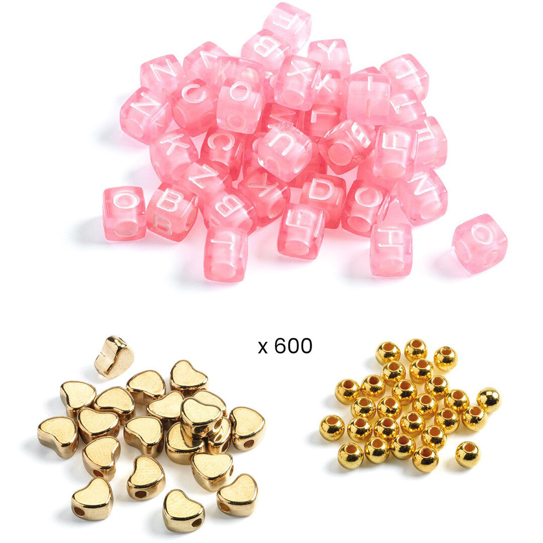 Drie stapels kralen van de Djeco kralenset: roze letterkralen, gouden hartjeskralen en kleine gouden ronde kralen.