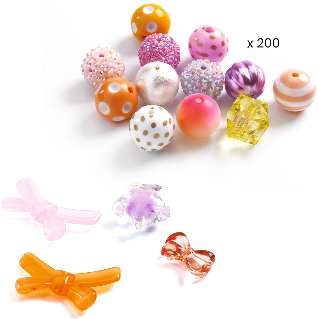 Een collectie van diverse Djeco kralen en strikjes in roze, oranje, paarse en witte tinten.