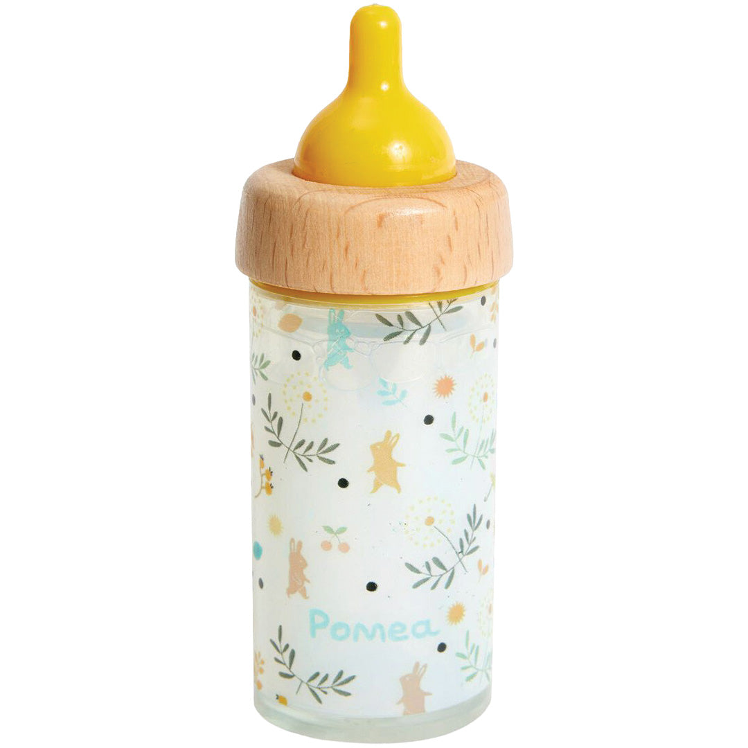 Djeco magische poppenfles met gele speen, houten ring en patroon van konijntjes en bloemen.