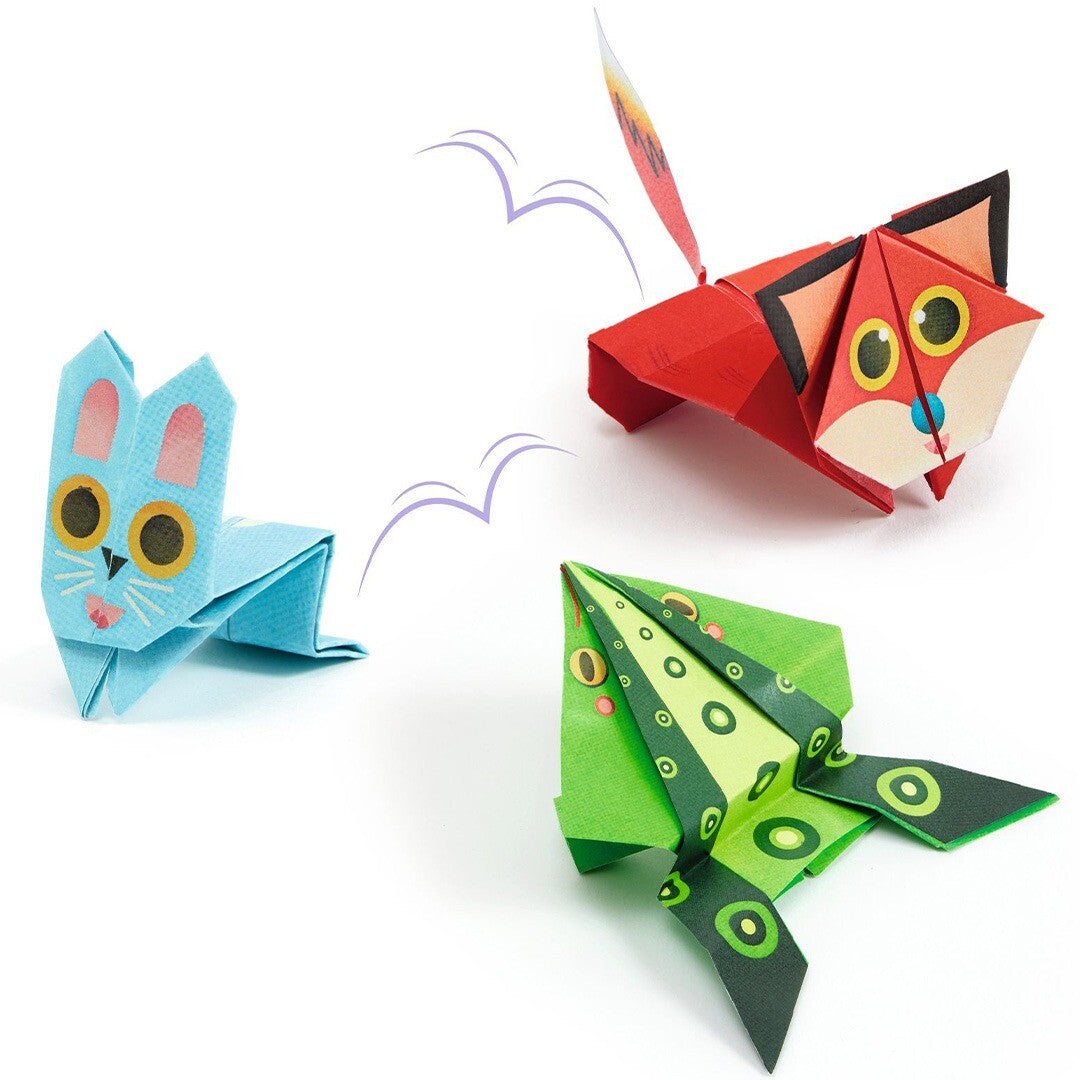 Drie gevouwen origami springende dieren: een blauwe kat, een rode vos en een groene kikker.