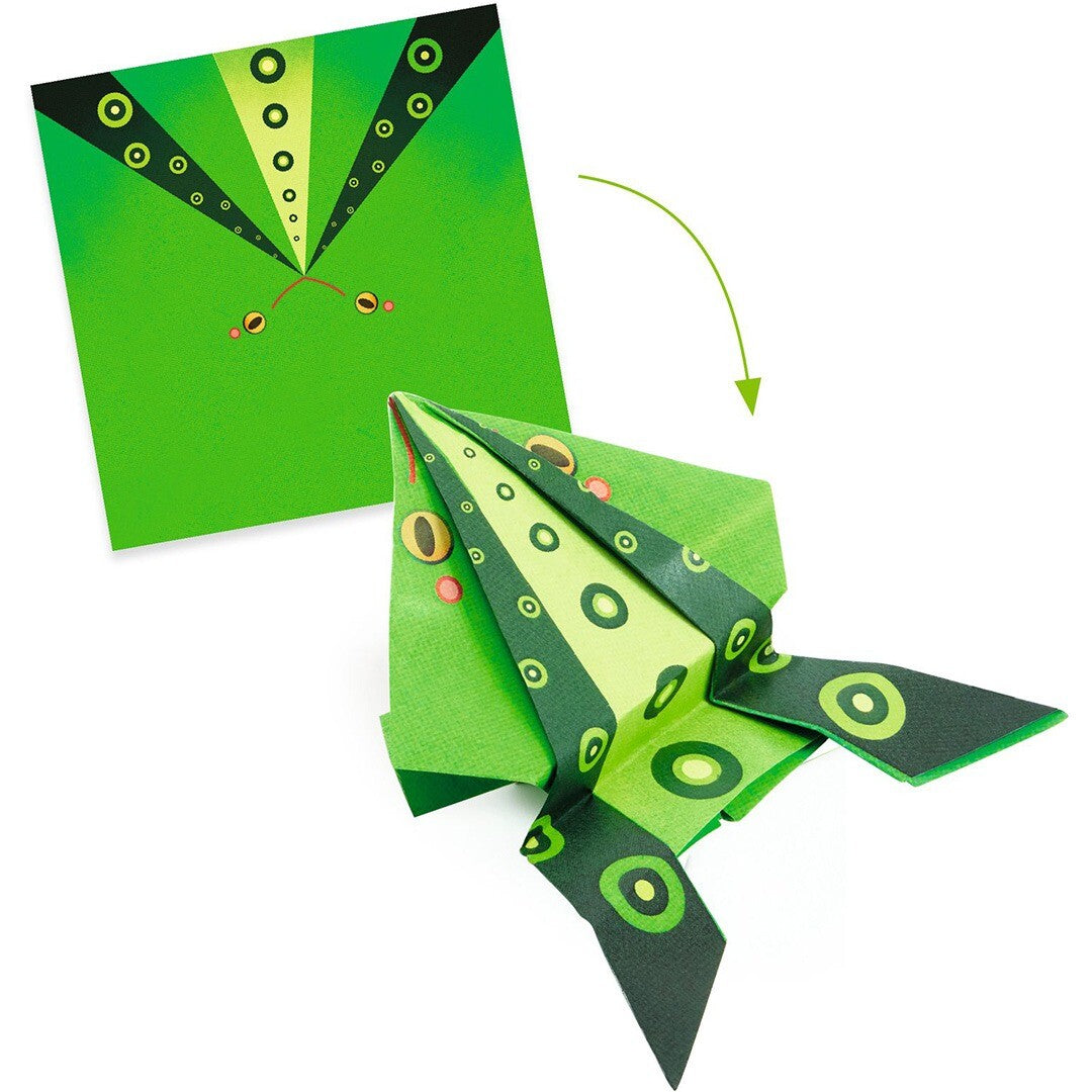 Een groen vel papier met kikkerpatroon naast een deels gevouwen groene origami springkikker.