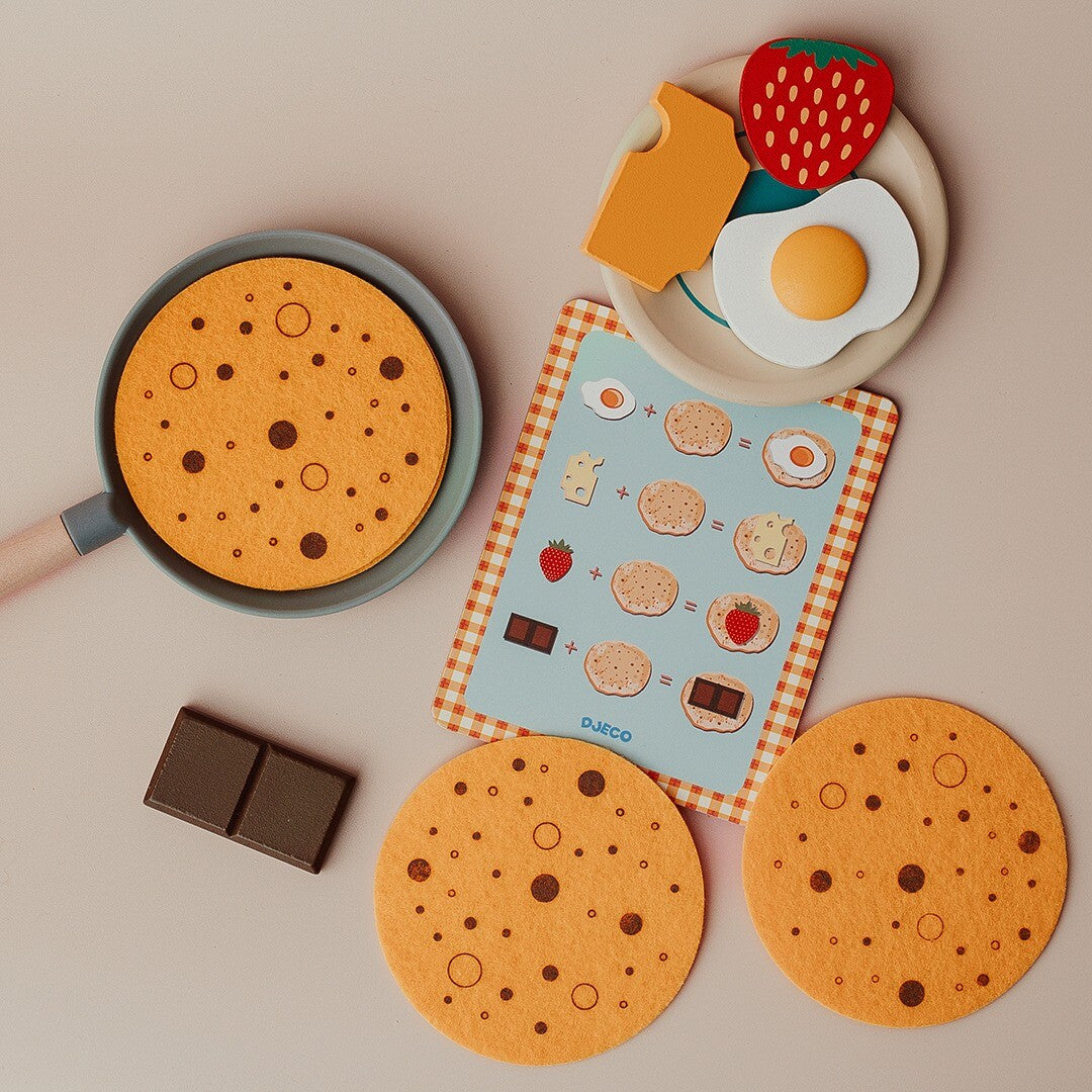 Bovenaanzicht van de Djeco pannenkoeken keukenspeelset met pan, pannenkoeken, receptenkaart en houten toppings.