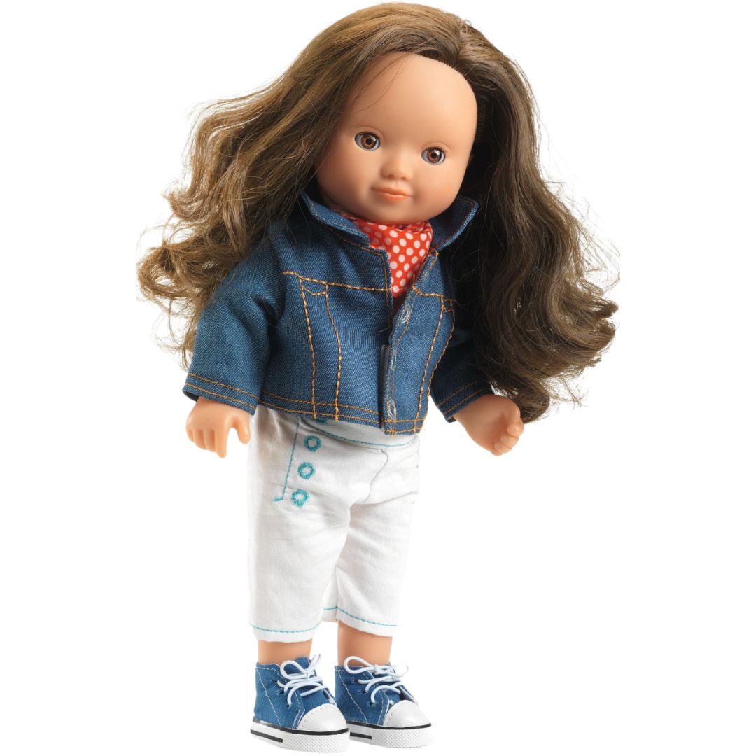 Een pop met lang bruin haar draagt de Djeco poppenkleding set met blauw denim jasje, rood gestippelde bandana, witte broek en blauwe sneakers.