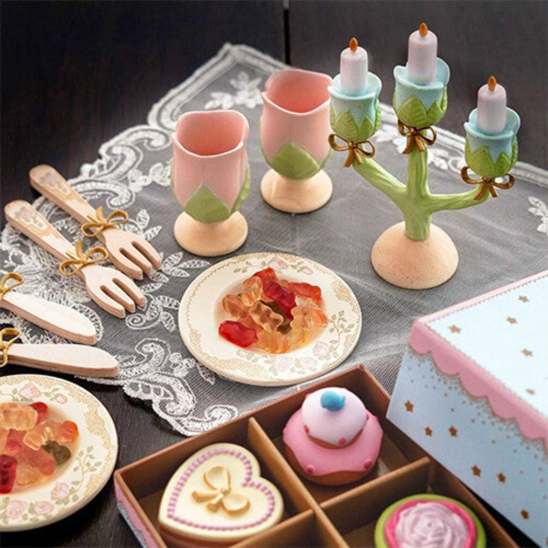 Het Djeco prinsessen speelservies gedemonstreerd op een tafel met snoepjes en speelgoedgebak.