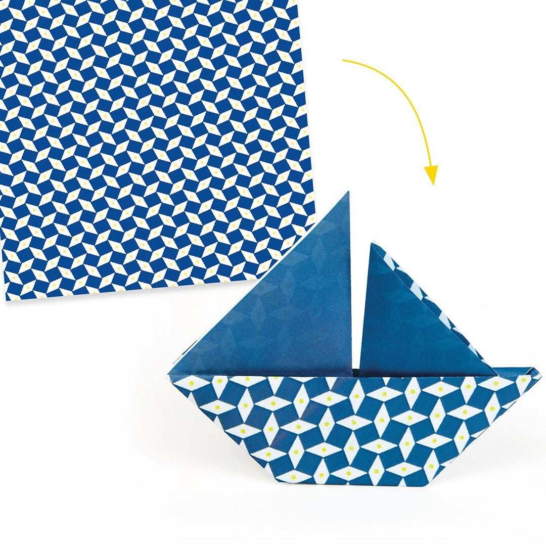 Een vel blauw-wit geometrisch origamipapier naast een gevouwen origami boot, met een pijl die de vouwrichting aangeeft.