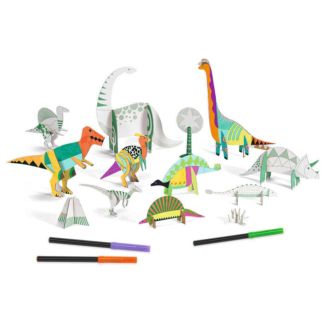 Een collectie van gekleurde en ongekleurde 3D papieren dinosaurussen en planten van de Djeco knutselset, met drie viltstiften.