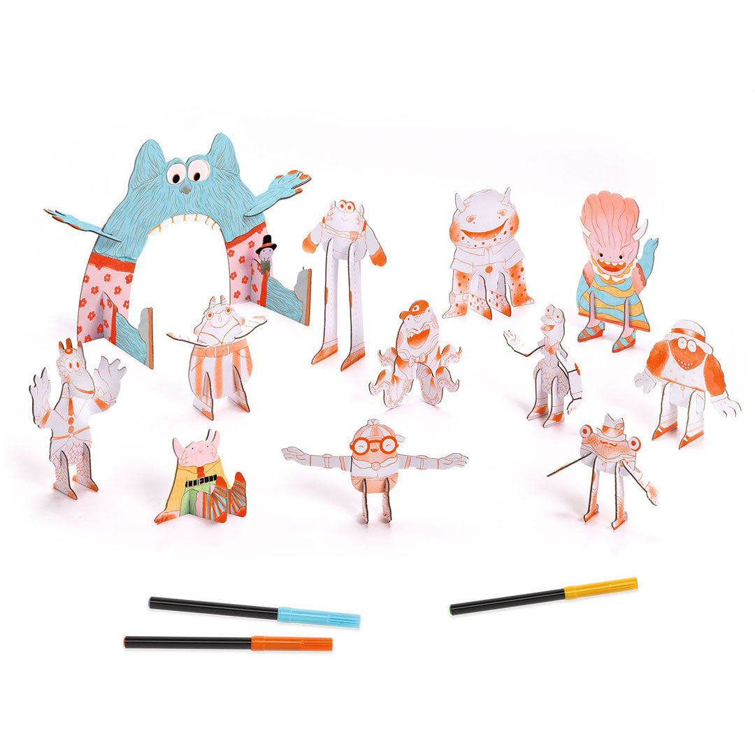 Een verzameling van gekleurde en ongekleurde Djeco 3D monster speelfiguren met kleurpotloden.