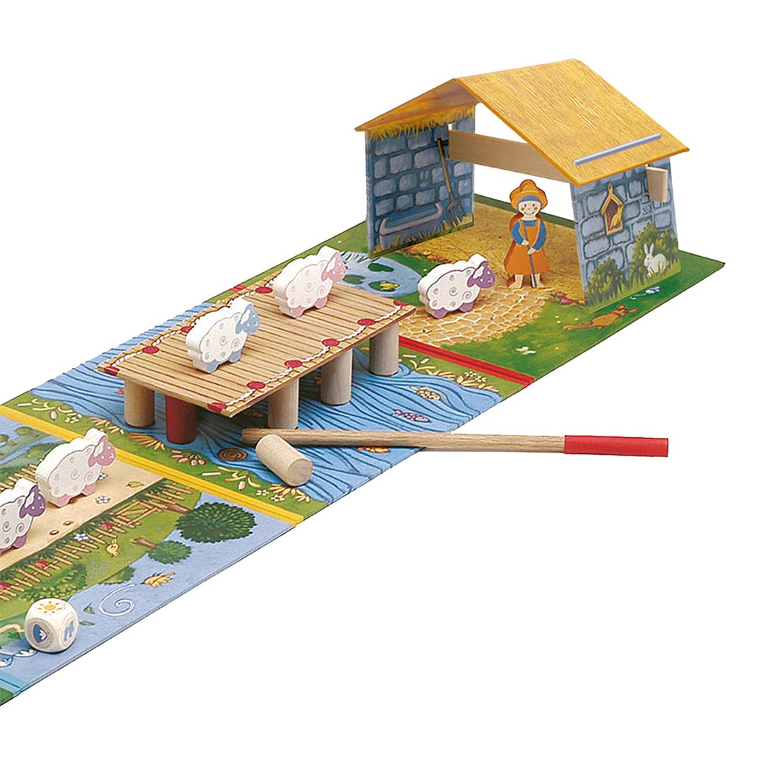 Detail van het Djeco bordspel Hop! Hop! Hop! met houten schapen op een brug en een boer bij een huisje.