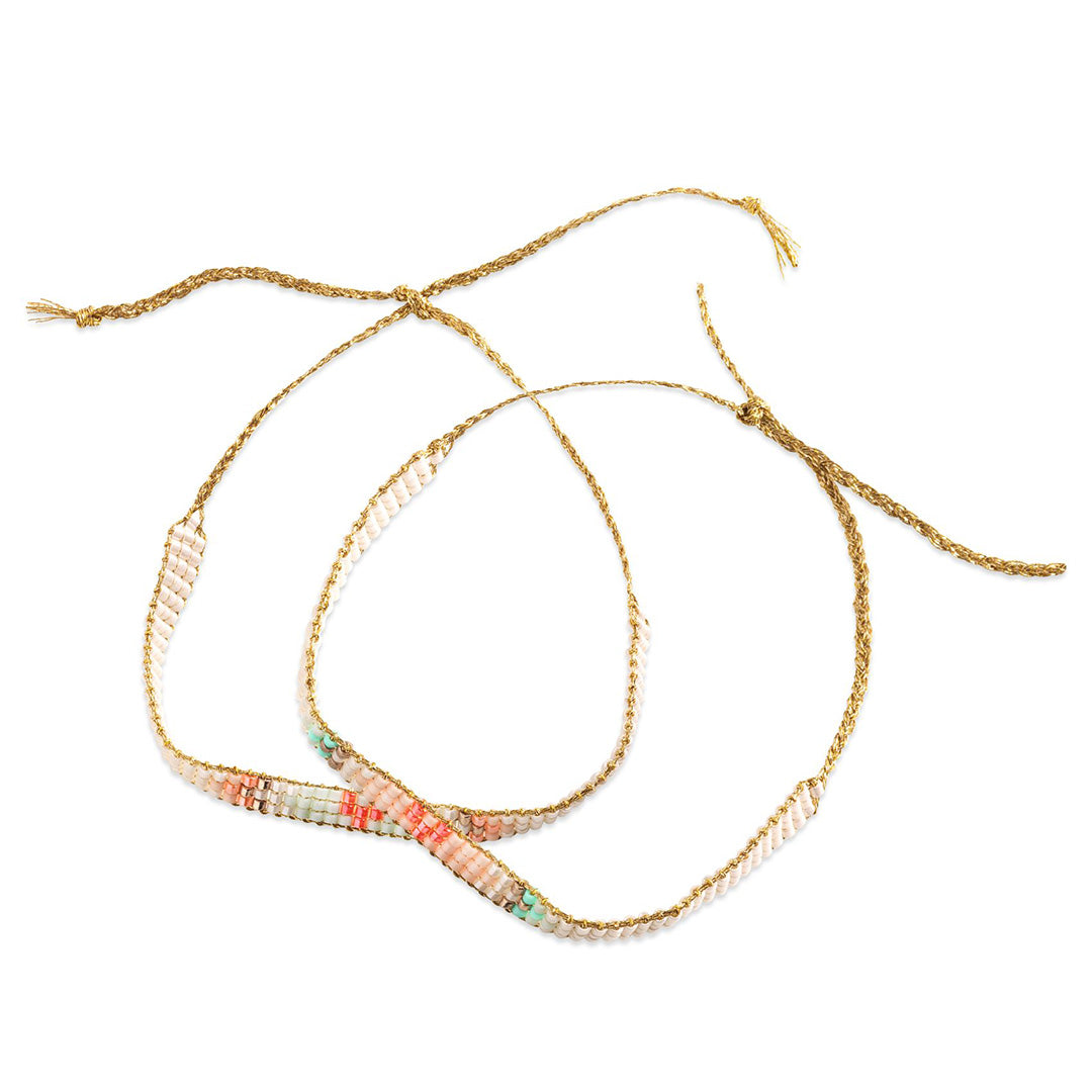 Twee gemaakte, kleurrijke kralenarmbandjes met gouden koordjes.