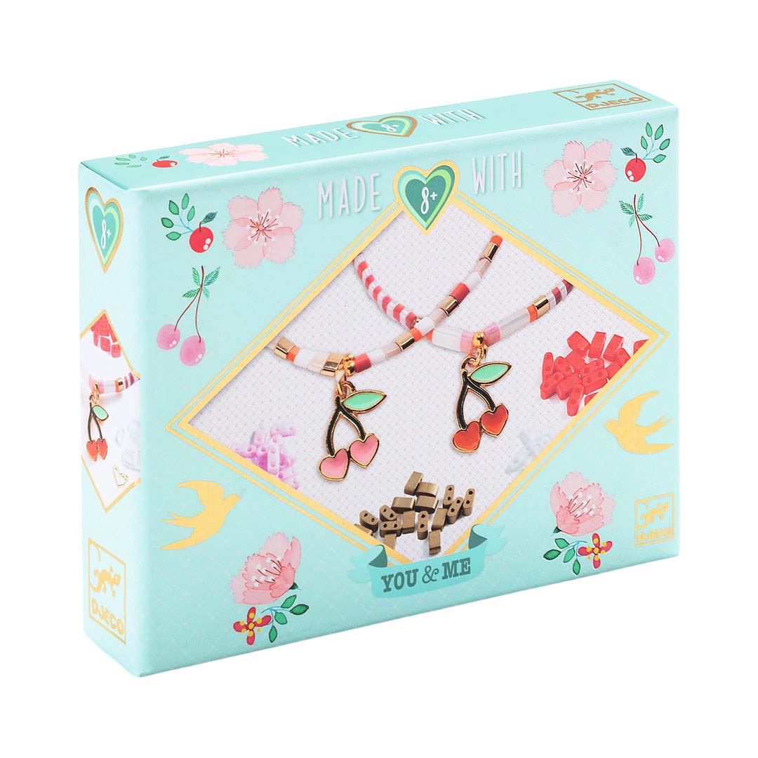 Djeco sieradenset verpakking met afbeelding van twee kersenarmbandjes en bloemen.