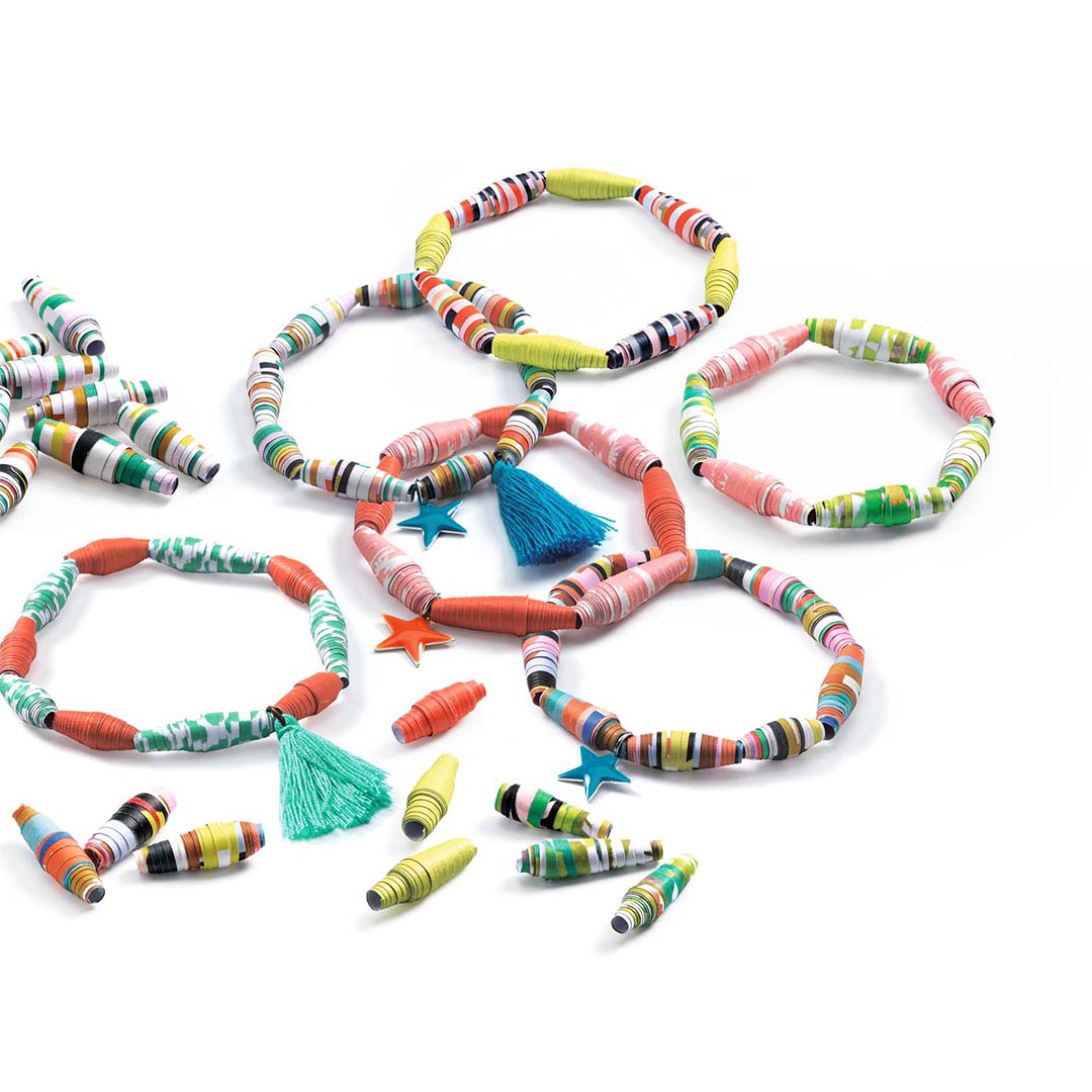 Kleurrijke papieren kralenarmbandjes en losse kralen, sommige versierd met kwastjes en sterbedels.