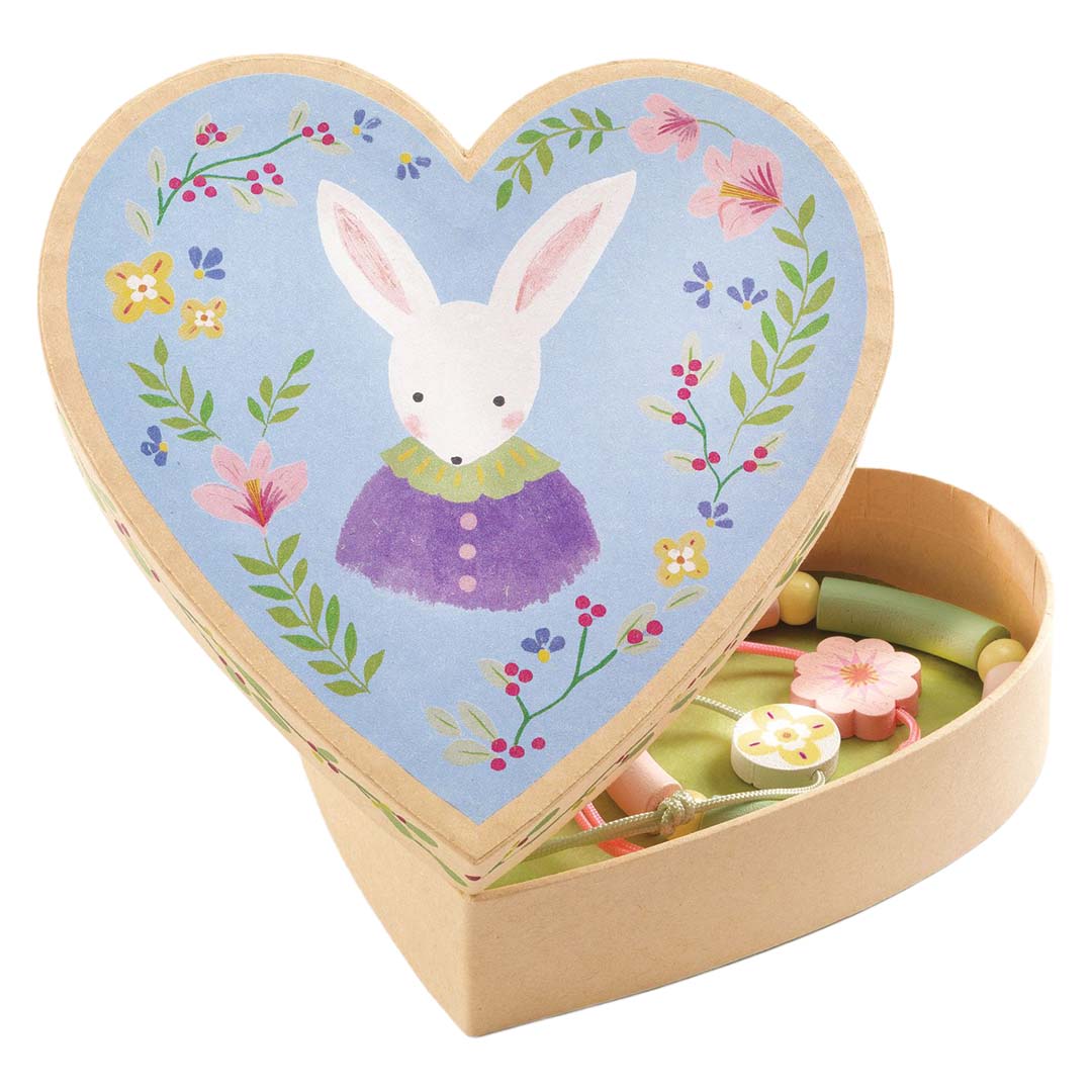Djeco sieradenset met een open hartvormig doosje met konijn en bloemen, en de armbandjes erin.