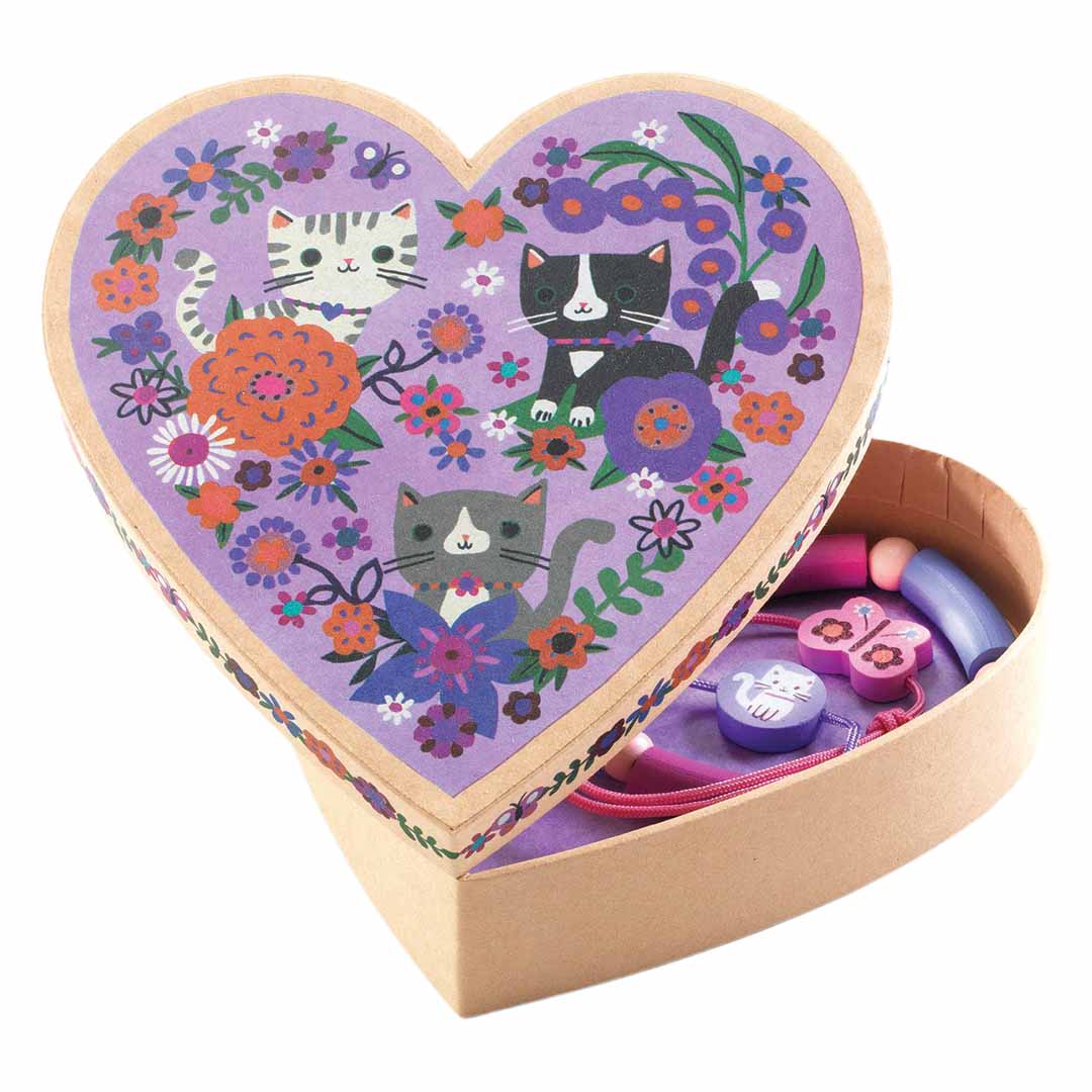 Djeco sieradenset met een open hartvormig doosje met katten en bloemen, waarin drie houten armbandjes liggen.