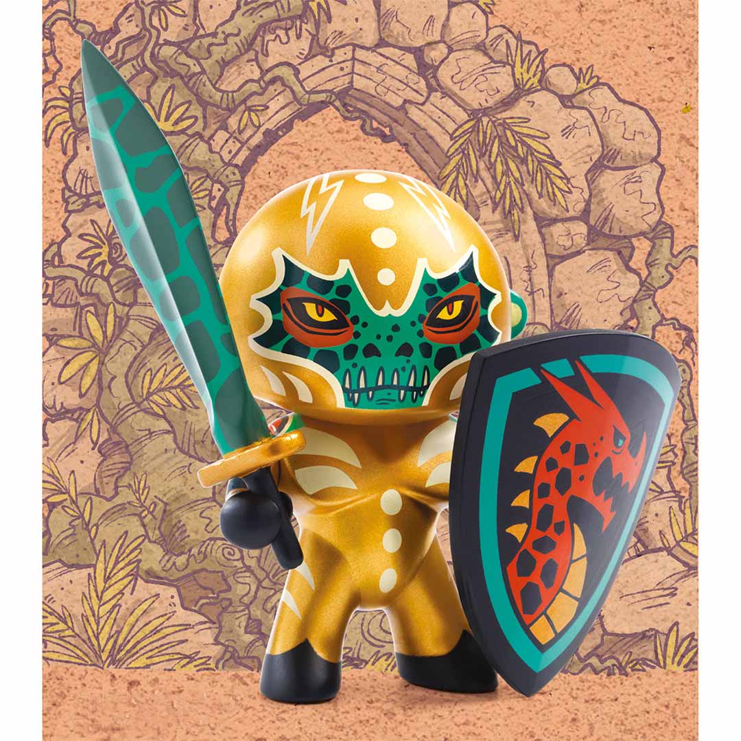 De Djeco Arty Toys Draco Knight actiefiguur met zwaard en schild, staand voor een geïllustreerde stenen boog.