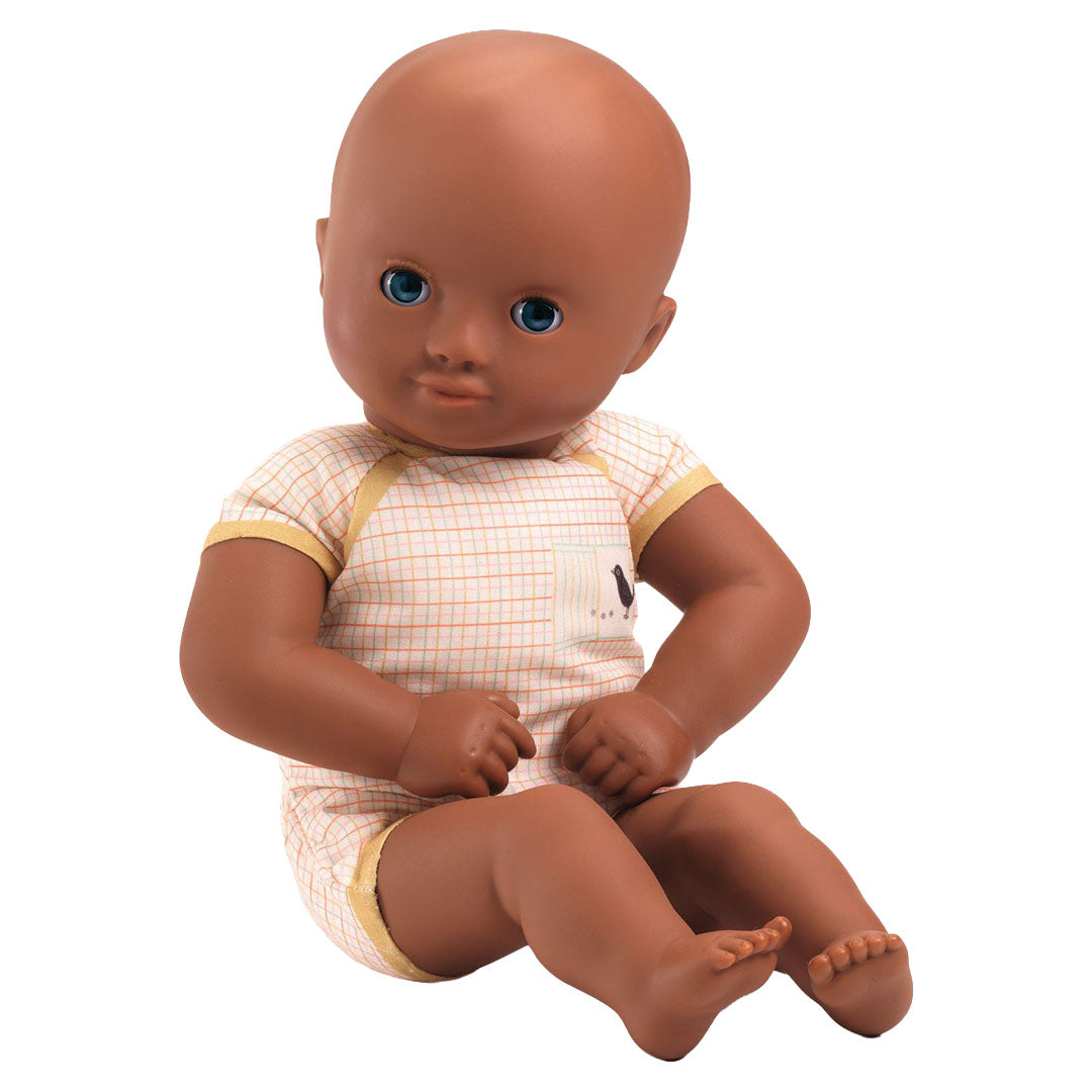 Djeco babypop met donkere huidskleur, blauwe ogen, zittend in een geruit rompertje met gele randen.