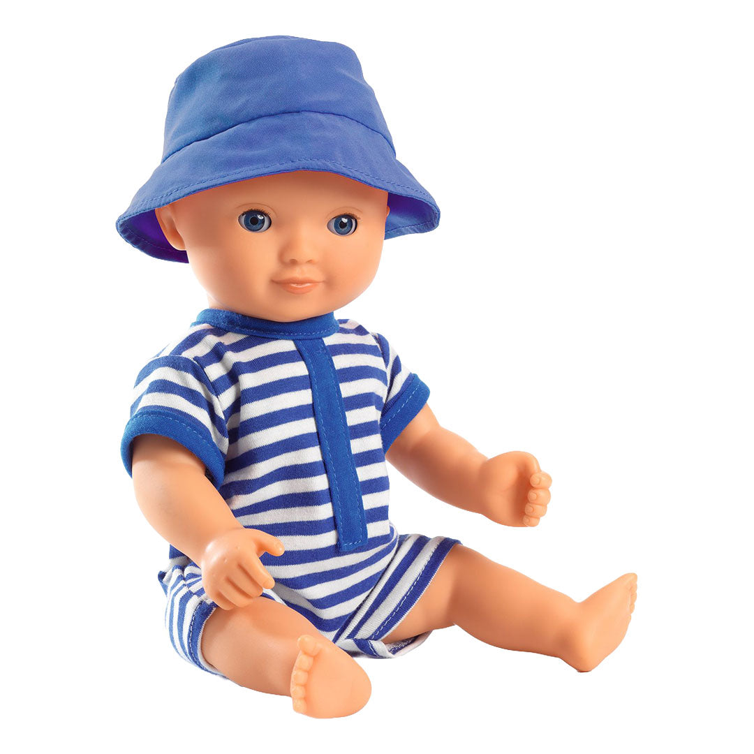 Djeco badpop Olive in een blauw-wit gestreept badpak en blauwe hoed.