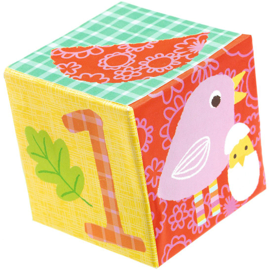 Een detailfoto van een kleurrijk stapelblok met het cijfer 1 en een roze vogel met kuiken.