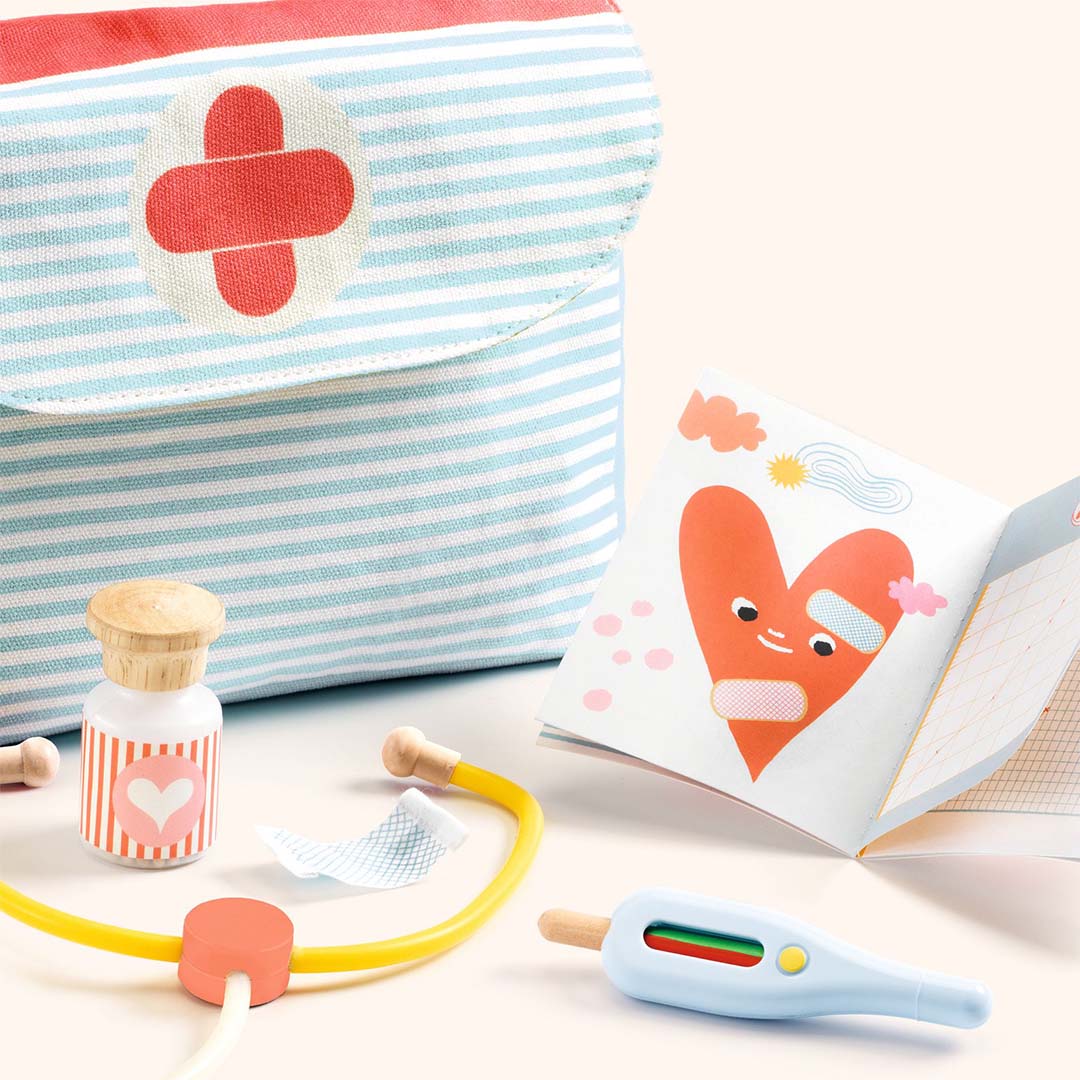 Detail van de Djeco dokterspeelset met stethoscoop, thermometer, flesje en boekje met hart.